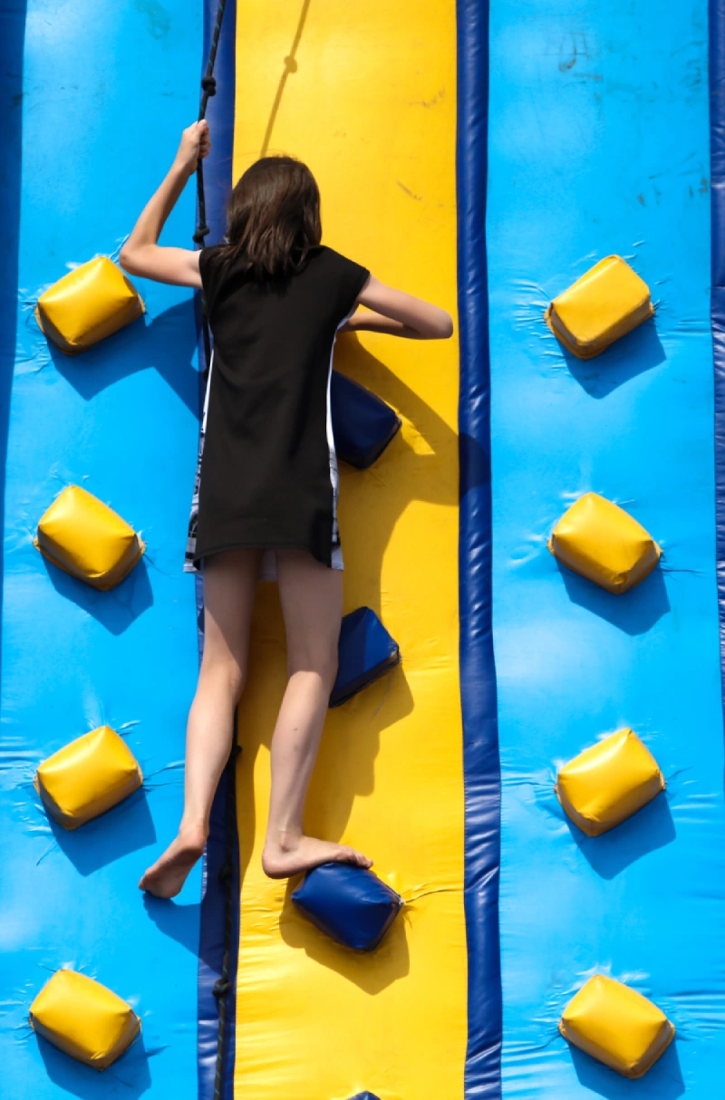 Girl on a mountaineering attraction in a park.